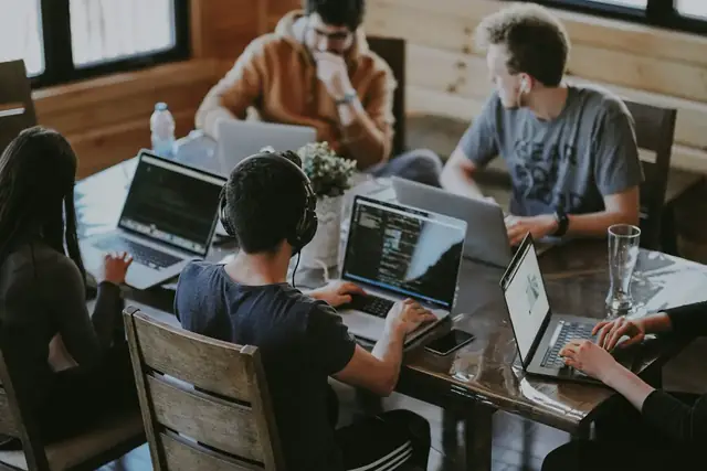 Four colleagues working together around a laptop.